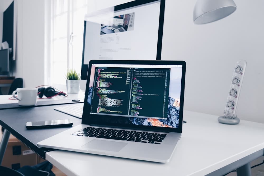 Developer's laptop open to a code editor on a home office desk